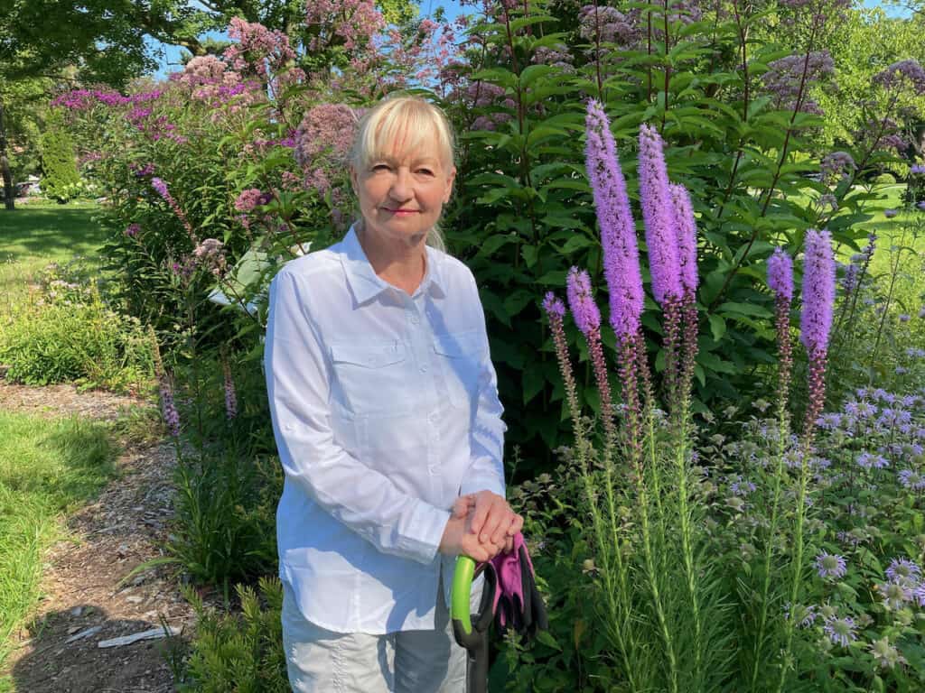 Klara Young-Chin in pollinator garden next to Dense Blazing Star in July 2021.