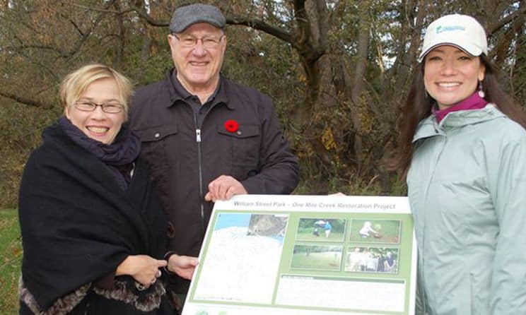 In November 2013 Niagara Peninsula Conservation Authority employee Katleya Young-Chin (right) and Friends of One Mile Creek member Gerry Beneteau met Deputy Lord Mayor Maria Bau-Coote at the William Street Park to show her one of the new interpretive signs erected highlighting the One Mile Creek restoration project. (Photo: Melinda Cheevers/Niagara This Week)